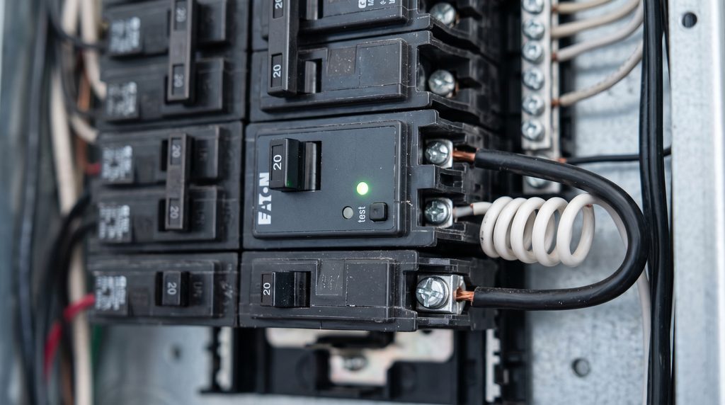 Close-up of an Eaton smart circuit breaker installed inside a residential home electrical panel for EV charging load management